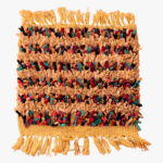 Handgeweven Berber tapijt met aardetinten en kleurrijke accenten in dieprood, groen en blauw, afgewerkt met gouden franjes