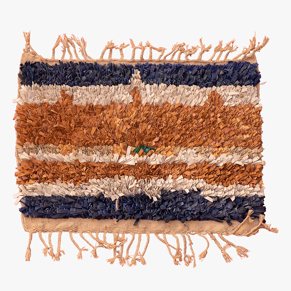 Handgeweven Berber tapijt met marineblauw, roestbruin, beige en groene accenten, traditionele esthetiek.