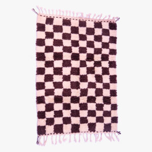 Handgeweven berber tapijt met een schaakbordpatroon in poederroze en diepbruine kleuren, afgewerkt met roze franjes.
