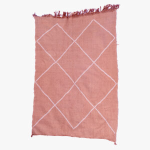 Zalmroze berber tapijt met witte geometrische diamantpatronen, omzoomd met franjes voor een strakke, hedendaagse uitstraling.