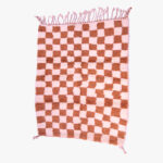 Roze en terracotta checkerboard berber tapijt, handgeweven met natuurlijke wol en afgewerkt met elegante franjes.