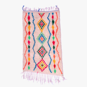 Traditioneel berber tapijt met een dynamisch patroon van geometrische figuren in roze, blauw, groen en geel op een crèmekleurige achtergrond.