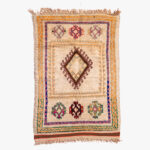 Handgeweven Berber tapijt met traditioneel diamantpatroon en kleurrijke accenten op een neutrale ondergrond, weerspiegelt Marokkaanse erfgoed.