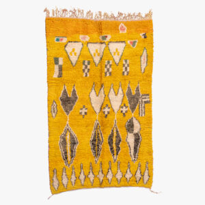 Geel Berber tapijt met traditionele diamantvormige patronen en symbolische Berber-tekens in aardetinten, afgewerkt met franjes.