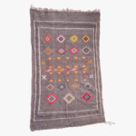 Elegant berber tapijt met traditionele patronen in neutrale en aardetinten, ideaal voor een verfijnde huisinrichting.