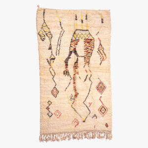 Handgeweven berber tapijt met natuurlijke crèmekleuren en traditionele zwarte, rode en gele motieven.