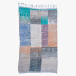 Handgeweven berber tapijt met een kleurrijk blokpatroon, mengend grijs, blauw, en aardetinten voor een eigentijdse uitstraling.