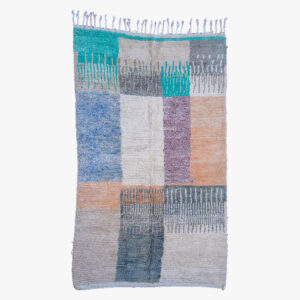 Handgeweven berber tapijt met een kleurrijk blokpatroon, mengend grijs, blauw, en aardetinten voor een eigentijdse uitstraling.