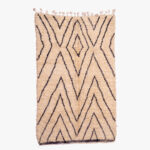 Elegant berber tapijt met een minimalistisch zigzagpatroon in natuurlijke beige en zwarte wol, handgeweven en stijlvol.