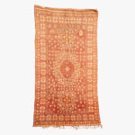 Handgeweven Berber tapijt met traditionele geometrische patronen in oranje en witte tinten, ideaal voor het toevoegen van een etnische sfeer aan elke ruimte.