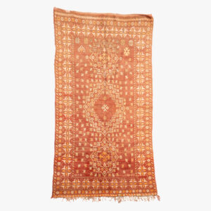 Handgeweven Berber tapijt met traditionele geometrische patronen in oranje en witte tinten, ideaal voor het toevoegen van een etnische sfeer aan elke ruimte.