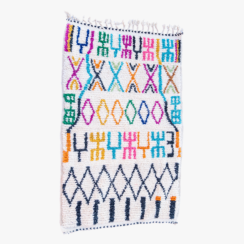 Kleurrijk Berber tapijt met traditionele patronen in blauw, roze, oranje en groen, met handgemaakte fransjes, ideaal voor een speelse ruimte.