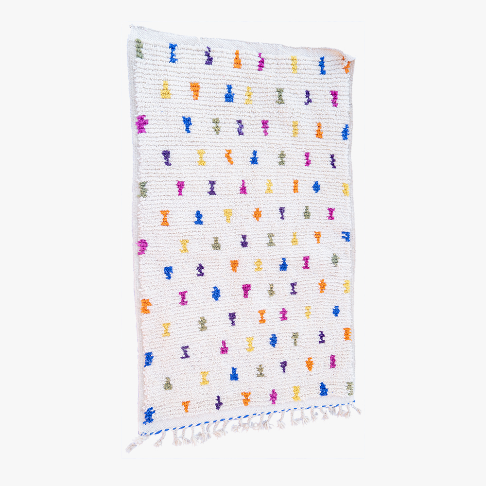 Wit Berber tapijt met een vrolijk patroon van meerkleurige abstracte vormen en delicate fransjes, een perfecte mix van traditioneel en eigentijds.