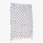 Minimalistisch wit Berber tapijt met discrete marineblauwe stippen en frisse fransjes, een elegante toevoeging aan elk hedendaags interieur.