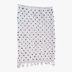 Minimalistisch wit Berber tapijt met discrete marineblauwe stippen en frisse fransjes, een elegante toevoeging aan elk hedendaags interieur.