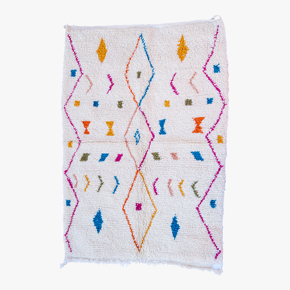 Handgeweven wit Berber tapijt met een levendig patroon van ruiten en symbolen in kleurrijke tinten, omlijst door een zachte roze rand.