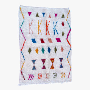 Handgeweven wit Berber tapijt met een kleurrijk assortiment van patronen, waaronder geometrische vormen en symbolische motieven.