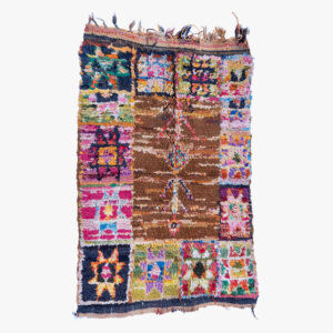 Veelkleurig Berber tapijt met een rijk patchwork van traditionele en abstracte patronen, afgewerkt met handgemaakte kwastjes.
