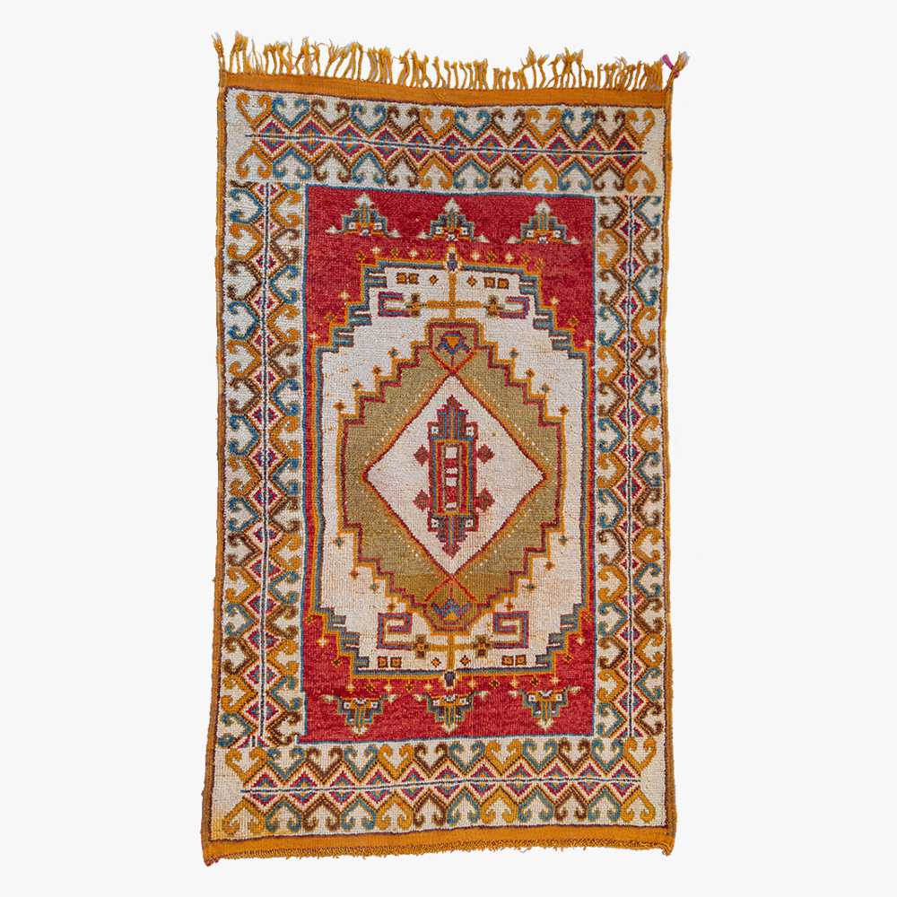 Traditioneel handgeweven Berber tapijt met een centraal medaillon in rood en beige, omringd door een veelkleurige geometrische rand.