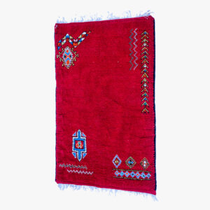 Traditioneel rood berber tapijt met blauwe en witte accenten en geometrische patronen, handgeweven en perfect voor huisdecoratie.